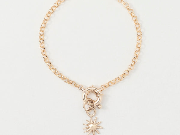 A gold bracelet featuring a golden sun charm centered on an 18cm bold belcher chain.