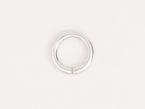 A silver round connector for charms or pendants on a white background