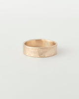 A thick textured gold band ring with a hammered finish, displayed against a white background.