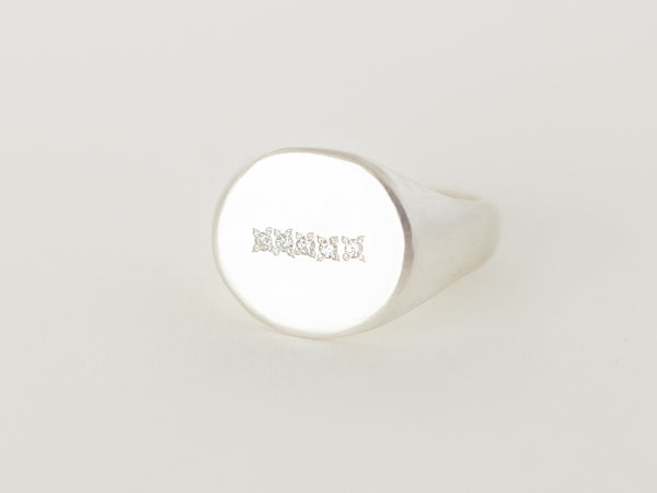 A silver signet ring with five consecutive Moissanites set in a row on a white background.