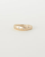 A smooth, dome-shaped gold ring with curved edges and small embedded sparkling stones arranged in a starry-night pattern