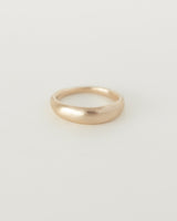 A simple gold dome-shaped ring with soft curved edges, displayed against a white background.