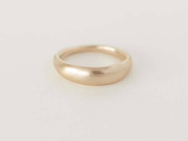 A simple gold dome-shaped ring with soft curved edges, displayed against a white background.